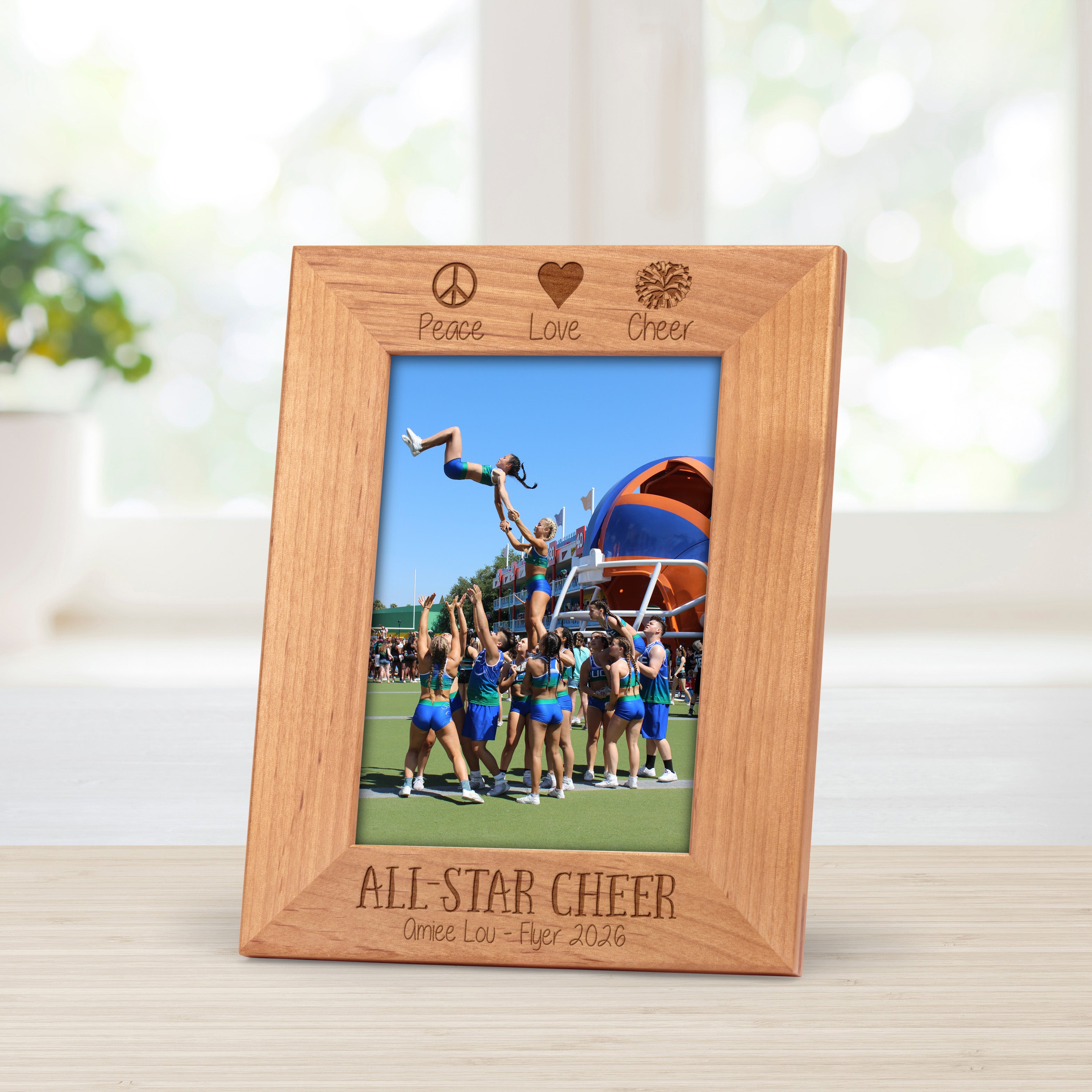 Cheer coach picture frame engraved with the phrase, "peace, love cheer" at the top.