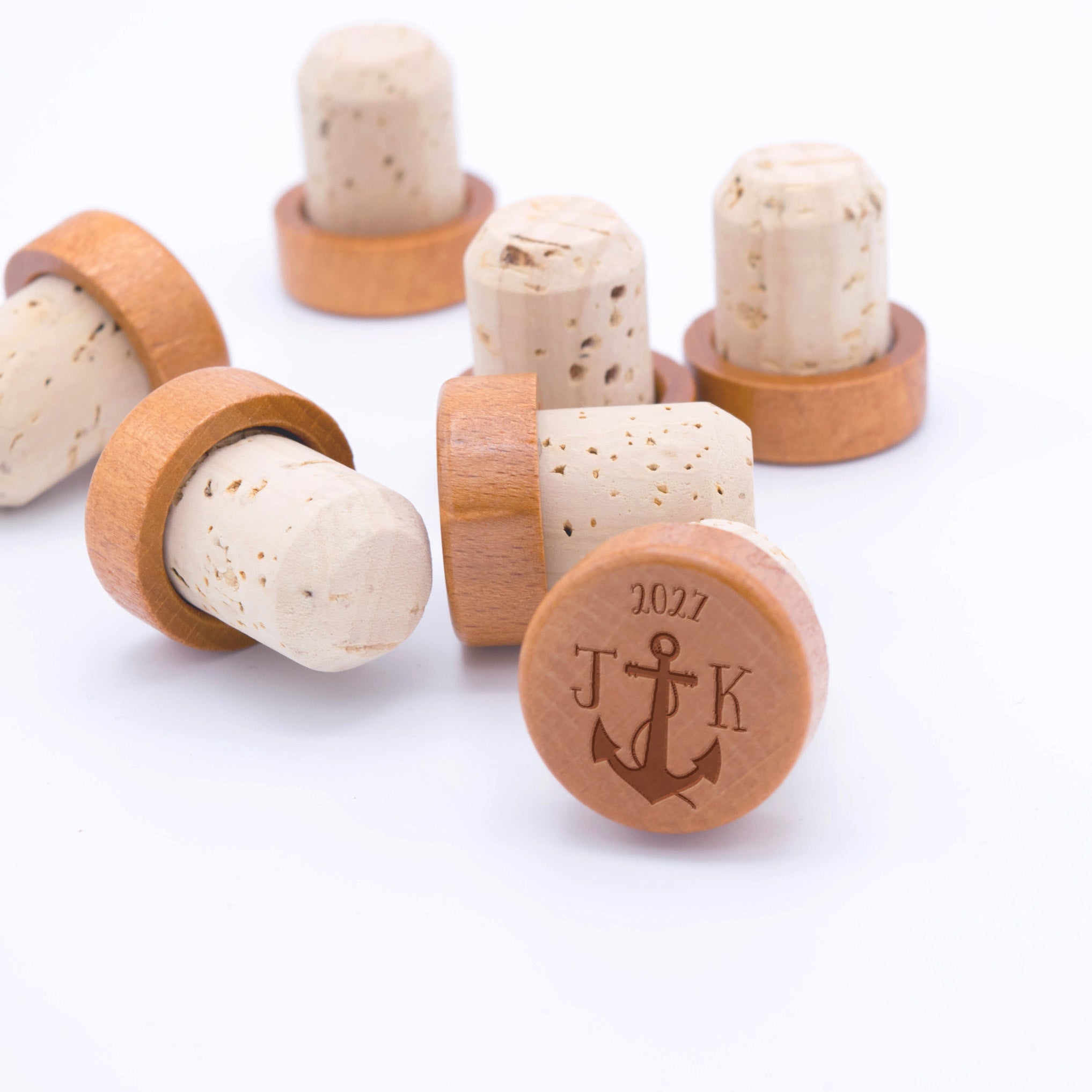 Custom cork stoppers engraved with an anchor and personalized with initials and year.