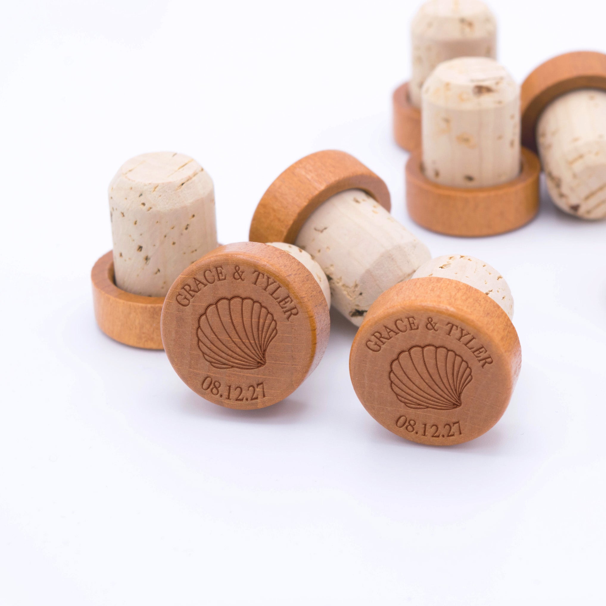 Custom champagne stoppers engraved with a seashell design and personalized with a couple’s names and custom date.